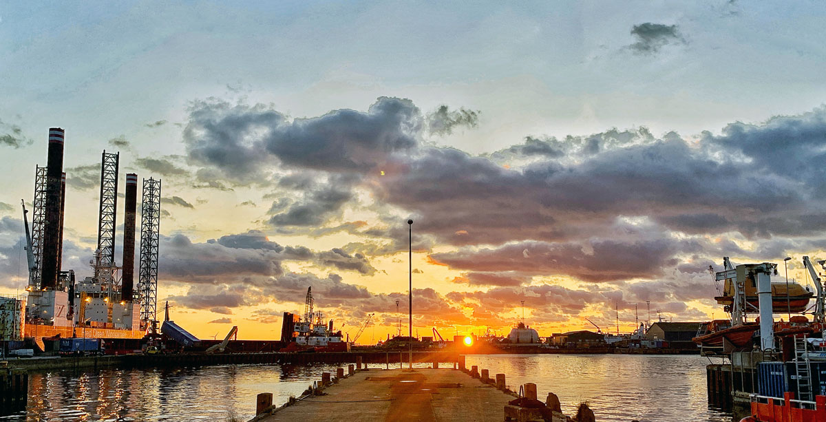 Esbjerg harbour at sunset, with a jack-up offshore wind service vessel at the quay; Spaceport North Sea stages its launch campaigns from this port